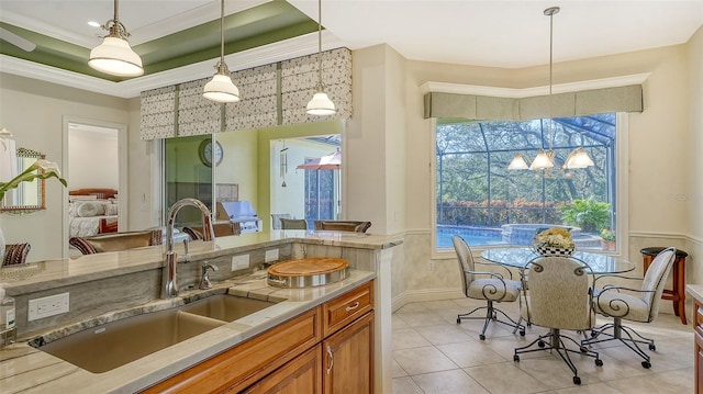 kitchen featuring sink, light tile patterned floors, hanging light fixtures, and ornamental molding