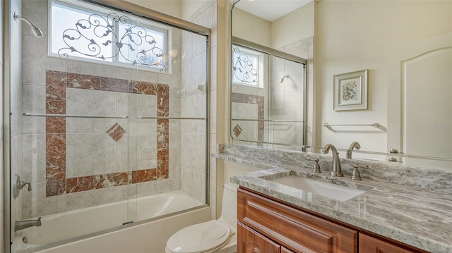 full bathroom with toilet, vanity, and combined bath / shower with glass door