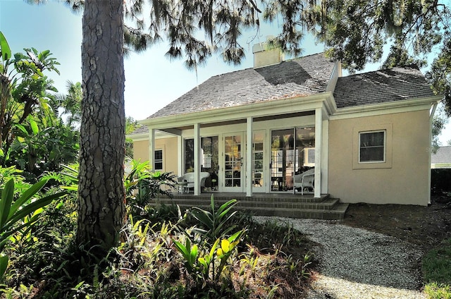 21 Bayhead Ln, Osprey, FL 34229 - rear view of property featuring a sunroom, stucco siding, and a chimney