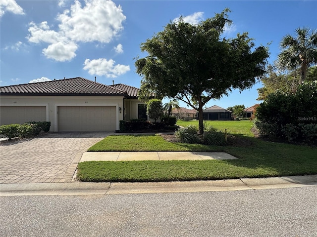 view of front of property with decorative driveway, stucco siding, an attached garage, a tiled roof, and a front lawn