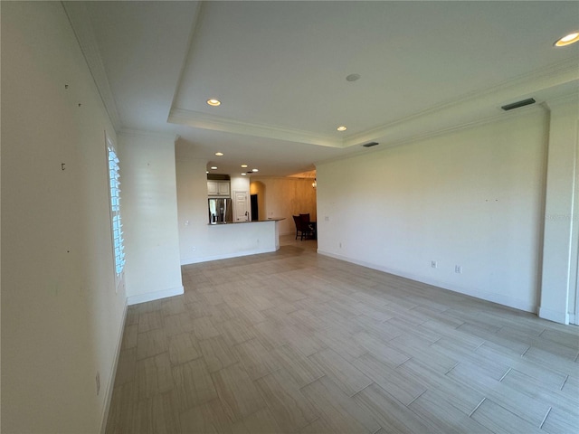 unfurnished living room featuring baseboards, a tray ceiling, crown molding, light wood-style floors, and recessed lighting