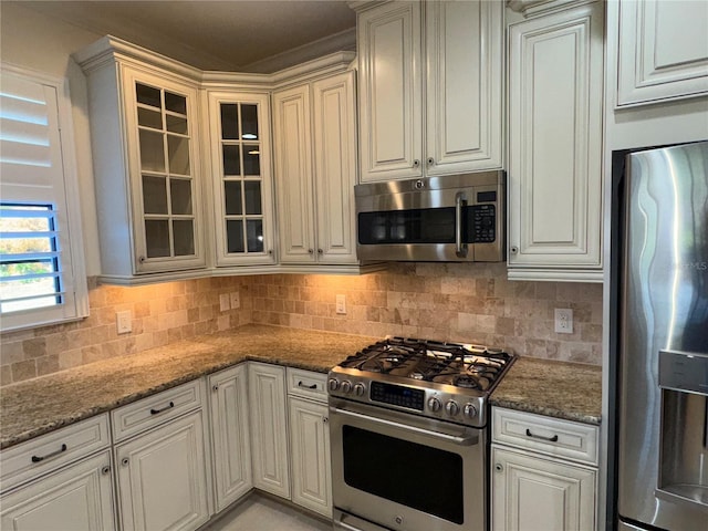 kitchen featuring stainless steel appliances, stone countertops, and glass insert cabinets