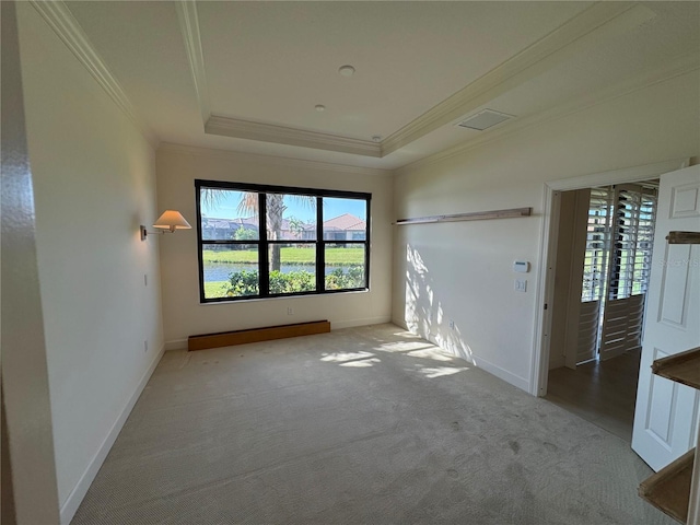 spare room featuring ornamental molding, a tray ceiling, carpet floors, and baseboards