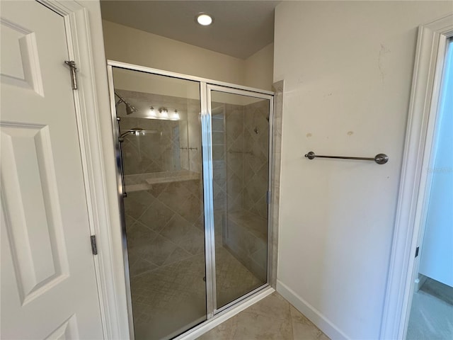 full bath with a shower stall and baseboards