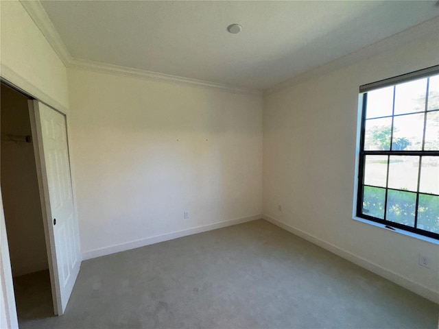 unfurnished bedroom with ornamental molding, a closet, carpet, and baseboards