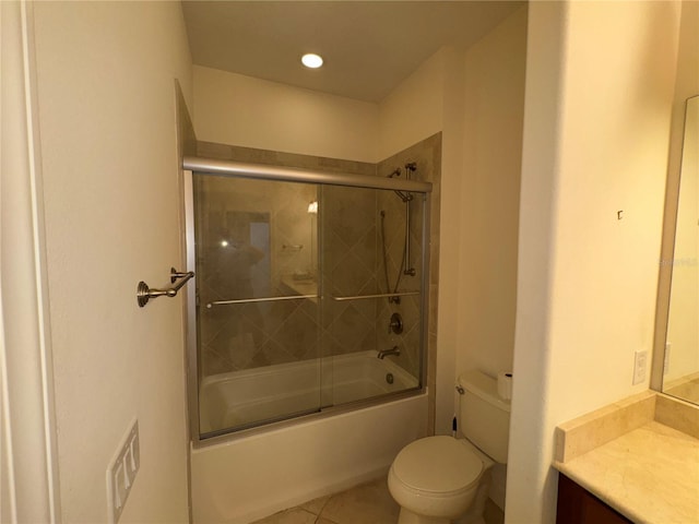 bathroom with tile patterned flooring, enclosed tub / shower combo, vanity, and toilet