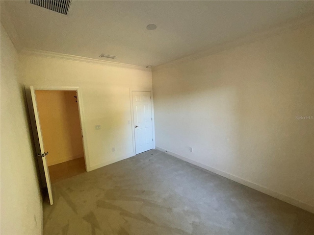 unfurnished bedroom featuring light carpet, ornamental molding, visible vents, and baseboards