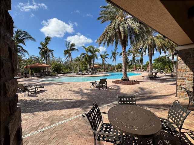 community pool with a gazebo and a patio area