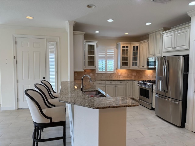 kitchen with glass insert cabinets, a kitchen breakfast bar, a peninsula, stainless steel appliances, and a sink