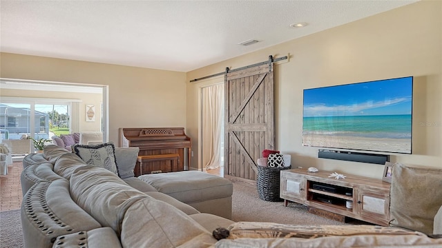 carpeted living room featuring a textured ceiling and a barn door