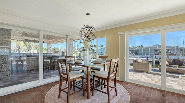 sunroom / solarium with a water view and a notable chandelier