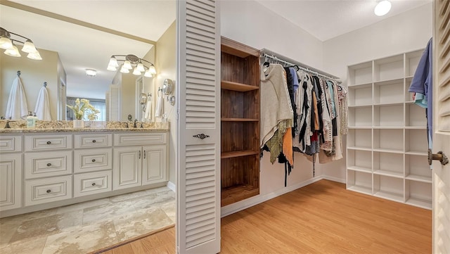 spacious closet with light hardwood / wood-style flooring and sink