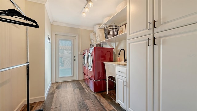 washroom featuring cabinets, dark hardwood / wood-style flooring, ornamental molding, and washing machine and clothes dryer