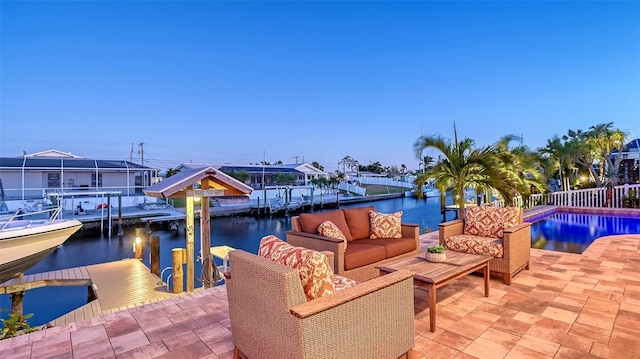 patio terrace at dusk with an outdoor living space, a water view, and a dock