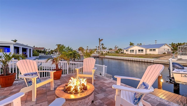 view of patio featuring a water view and a fire pit