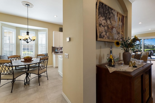 tiled dining room with a chandelier