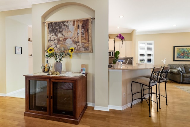 interior space with light hardwood / wood-style flooring, a kitchen bar, and kitchen peninsula