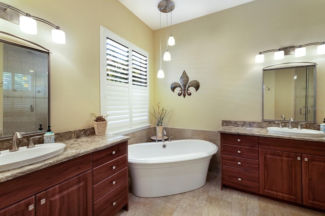 bathroom with vanity and shower with separate bathtub