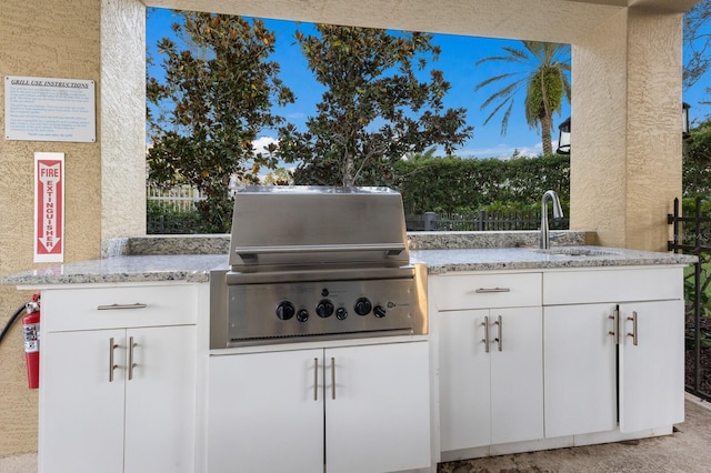 view of patio with area for grilling and sink