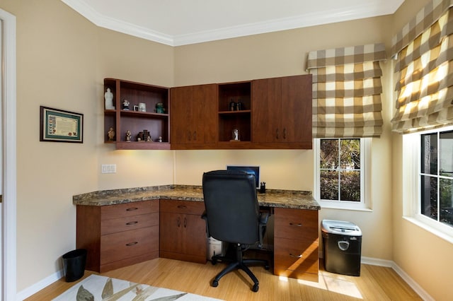 office area featuring crown molding, built in desk, and light wood-type flooring