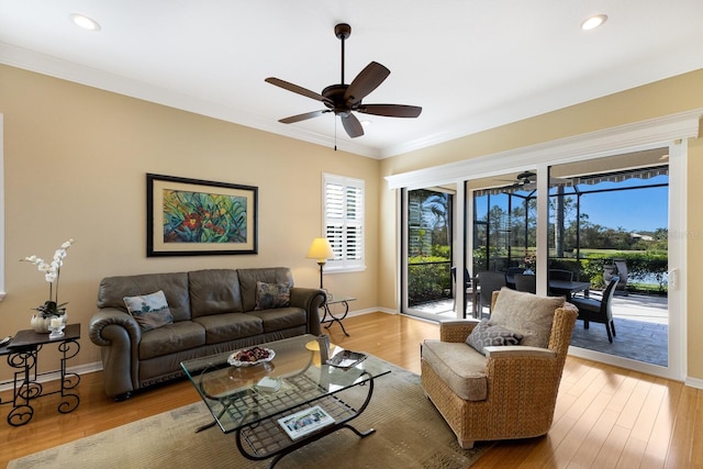 living room featuring light hardwood / wood-style floors, ornamental molding, and ceiling fan