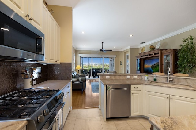 kitchen with sink, crown molding, stainless steel appliances, and tasteful backsplash