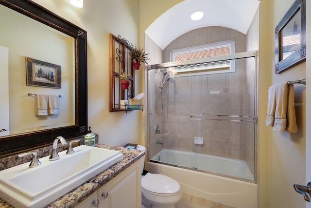 full bathroom with vanity, toilet, combined bath / shower with glass door, and lofted ceiling