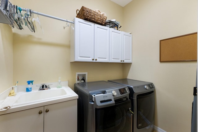 laundry area with sink, cabinets, and separate washer and dryer