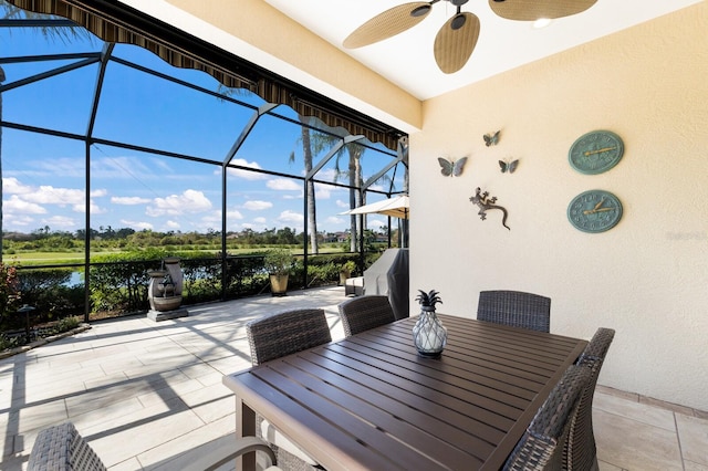 view of patio featuring ceiling fan and glass enclosure