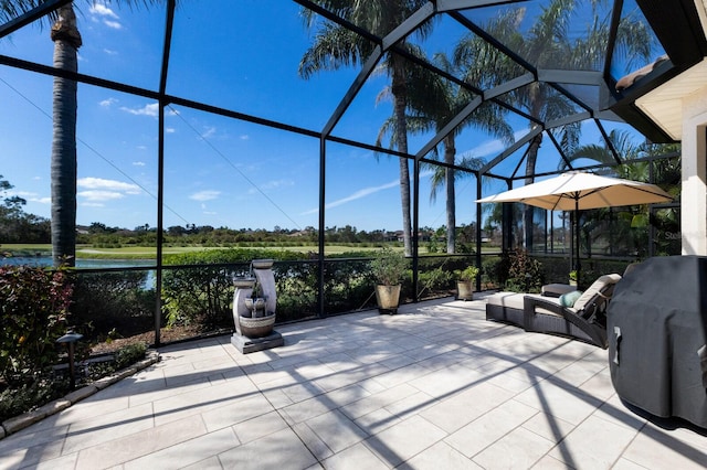 view of patio / terrace featuring area for grilling, a lanai, and a water view