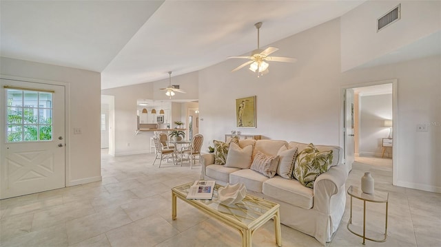 living area featuring high vaulted ceiling, visible vents, baseboards, and light tile patterned flooring