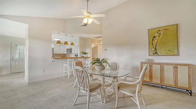 dining space featuring a ceiling fan, baseboards, and light tile patterned floors