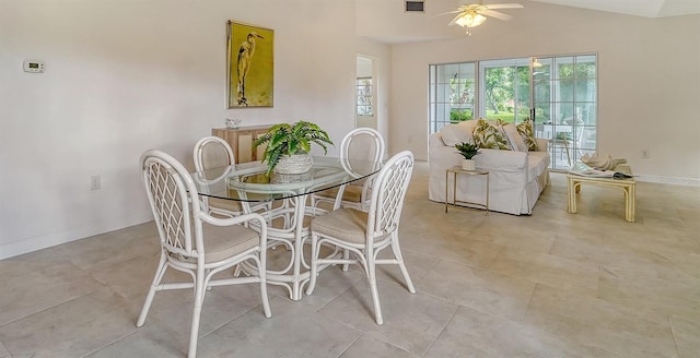 dining space featuring vaulted ceiling, plenty of natural light, a ceiling fan, and baseboards