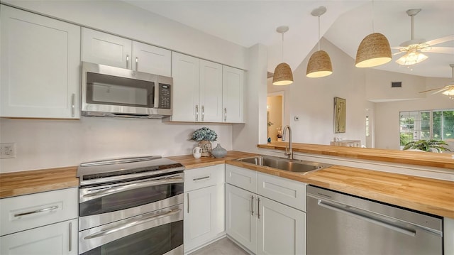 kitchen featuring butcher block countertops, appliances with stainless steel finishes, and a sink