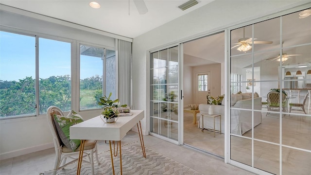 office space with a wealth of natural light, a sunroom, visible vents, and baseboards