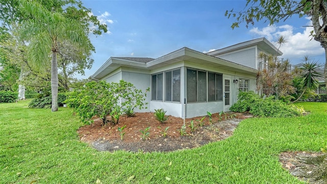 view of side of property featuring a yard and a sunroom