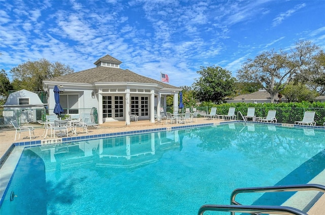 view of swimming pool with a patio, french doors, and fence