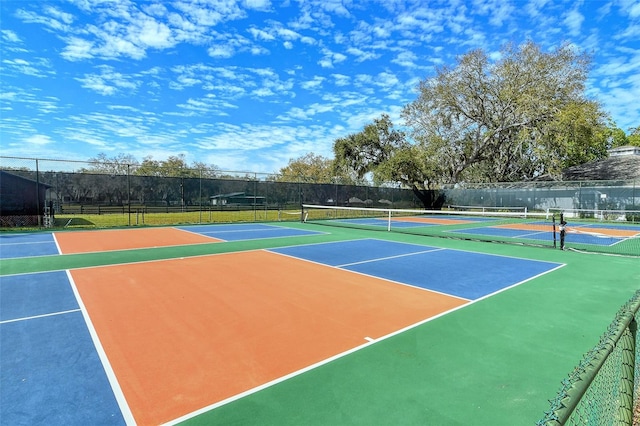 view of tennis court featuring community basketball court and fence