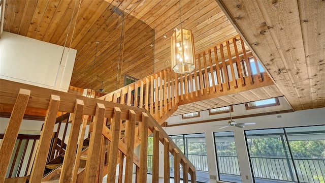 stairs with high vaulted ceiling, a skylight, and ceiling fan