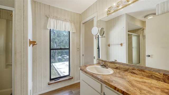 bathroom with a wealth of natural light, vanity, and wood-type flooring