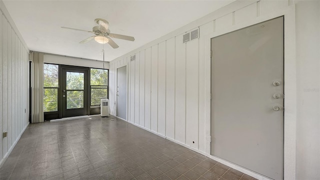 spare room featuring wooden walls and ceiling fan