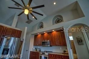 kitchen with stainless steel appliances, high vaulted ceiling, and ceiling fan