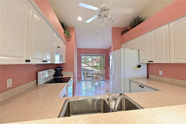 kitchen with white appliances, sink, hanging light fixtures, and white cabinets