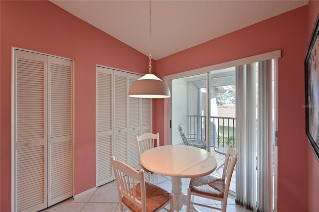 tiled dining space with lofted ceiling