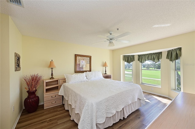 bedroom featuring a textured ceiling, dark hardwood / wood-style floors, and ceiling fan