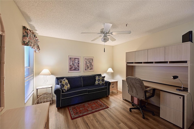 home office featuring a textured ceiling, light hardwood / wood-style floors, and ceiling fan