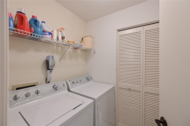 washroom featuring washing machine and dryer and a textured ceiling