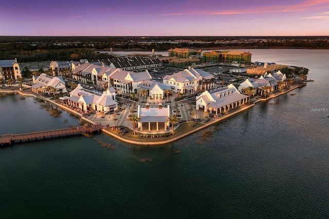 aerial view at dusk featuring a water view