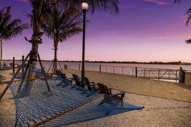 patio terrace at dusk featuring a water view