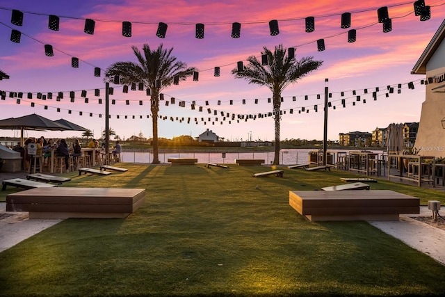 view of property's community featuring a lawn and a water view